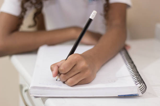 istock Hands of a child studying Doing Her Homework 1543888706