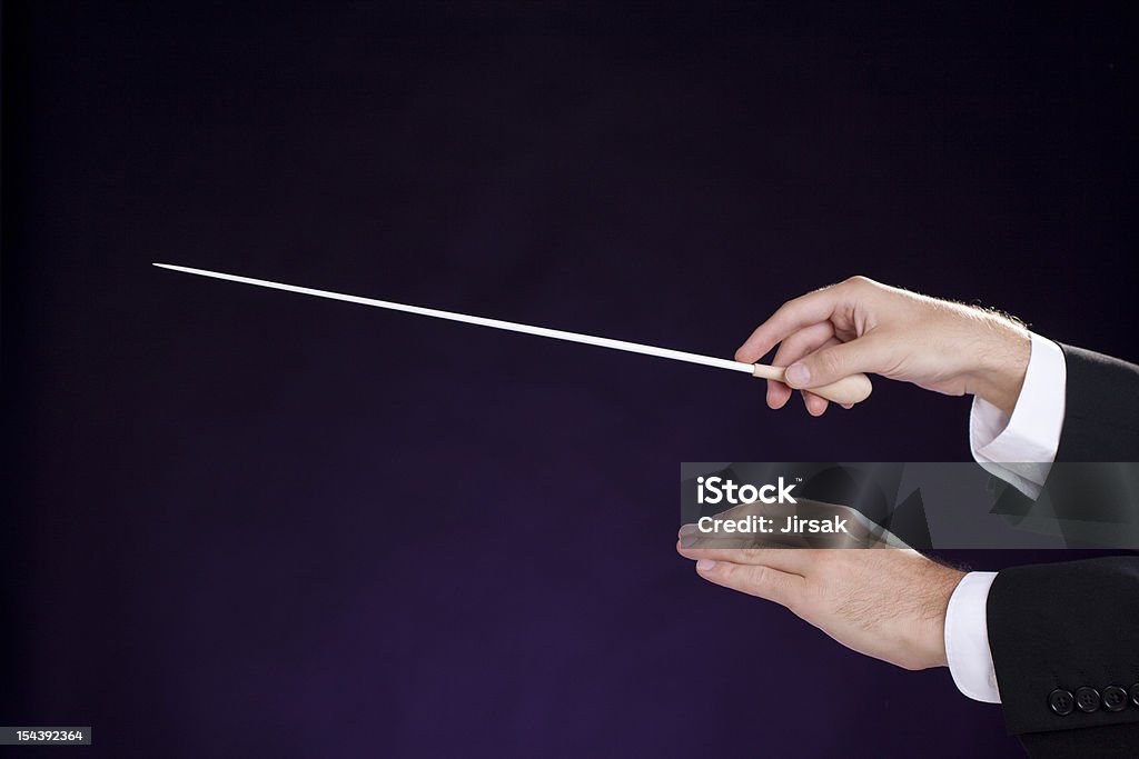 Conductor Male orchestra conductor hands, right with baton. Purple background. Musical Conductor Stock Photo