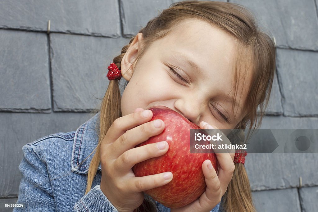 girl eating an apple little girl eating a red apple Apple - Fruit Stock Photo