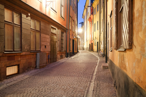 Sweden. Stockholm. 05.18.2022. Close up view of narrow street between two yellow buildings.