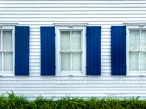 white curtains behind blue shutters