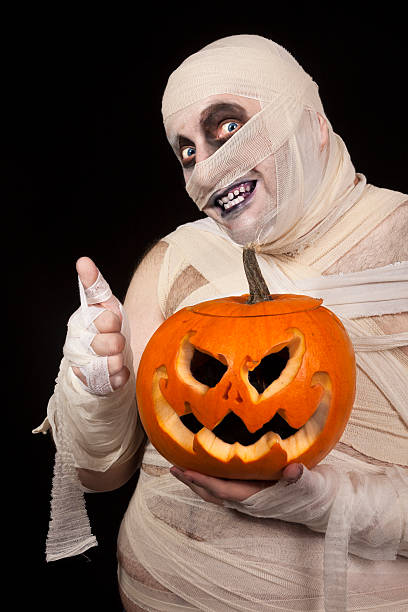 istock Scary  Mummy with Halloween pumpkin holding thumbs up 154399578