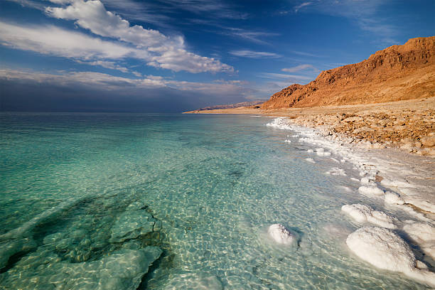 Panoramic view of Dead Sea coastline with water and shore View of Dead Sea coastline dead sea stock pictures, royalty-free photos & images