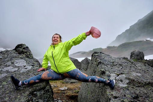 Girl on a splits between two stones in foggy weather