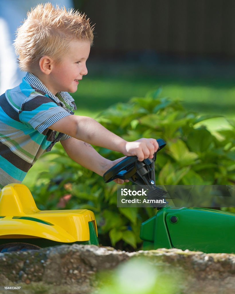 Boy with tractor Happy little boy playing with a toy tractor. Child Stock Photo