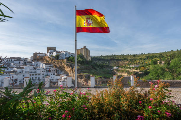 Flag of Spain and Setenil de las Bodegas Skyline - Setenil de las Bodegas, Andalusia, Spain stock photo