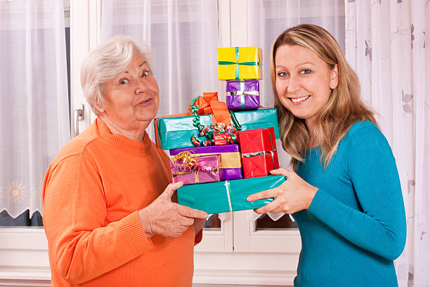 istock old and young woman holding presents 154414763