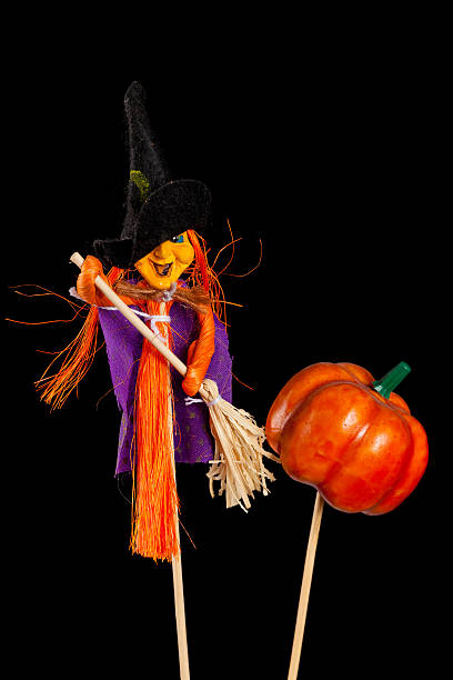 Hand-crafted witch and pumpkin Halloween decorations isolated on black background stock photo