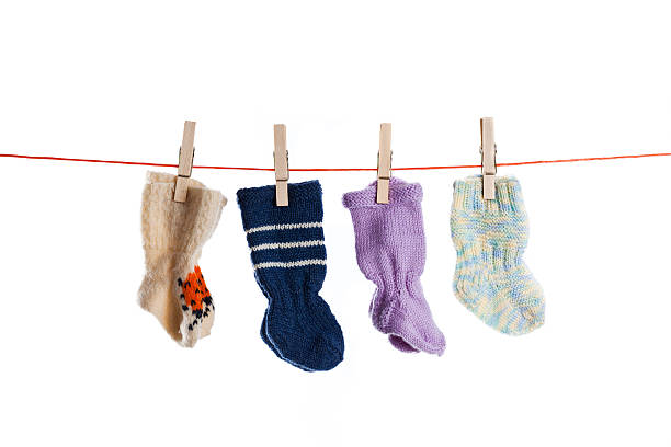 calze di lana bambino appendere su corda stendibiancheria con sfondo bianco - sock wool multi colored isolated foto e immagini stock