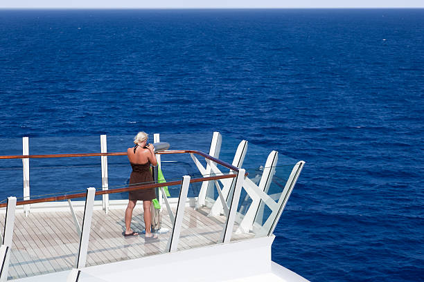istock Blonde woman watching the sea with binoculars on ship deck 154417373