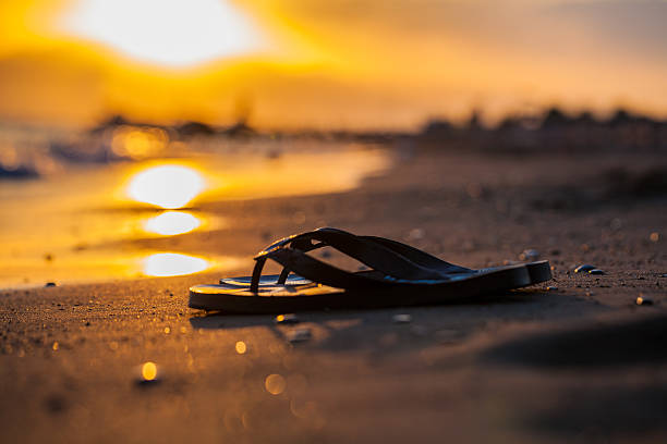 sandale auf den strand und sonnenuntergang. - sunset beach sky heat stock-fotos und bilder