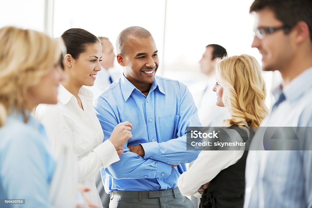Laughing  businesspeople talking in the office. Smiling  group of  businesspeople discussing.    Networking Stock Photo