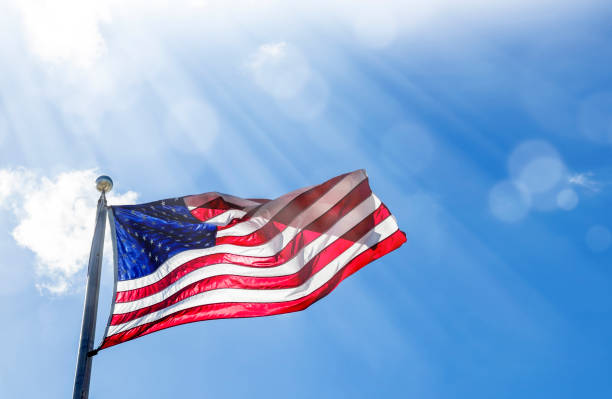 istock American flag at flagpole over sunny blue sky 1544242877
