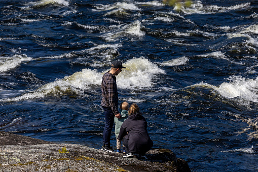 Storforsen, Sweden June 9, 2023 A young family with a baby vist the Storforsen river rapids on the Pitea River in the Norbbotten region.