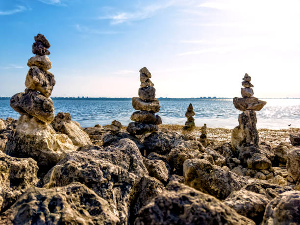Balanced rock piles on rocky beach in sunny day