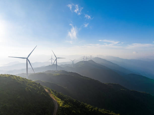 A wind turbine at the top of a mountain on a sunny day A wind turbine at the top of a mountain on a sunny day rotary blade stock pictures, royalty-free photos & images