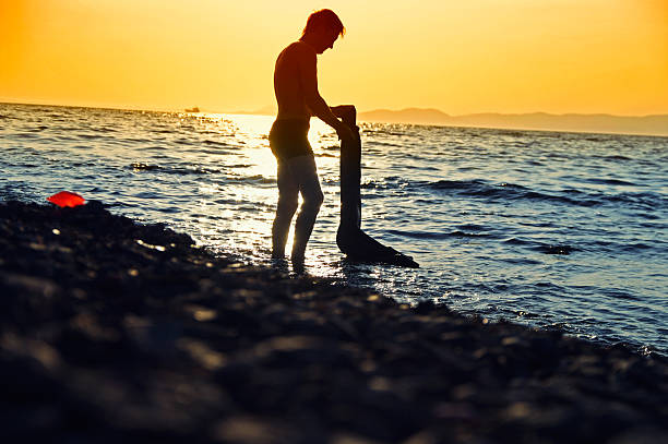 homme sur le coucher de soleil sur la mer - witterung photos et images de collection