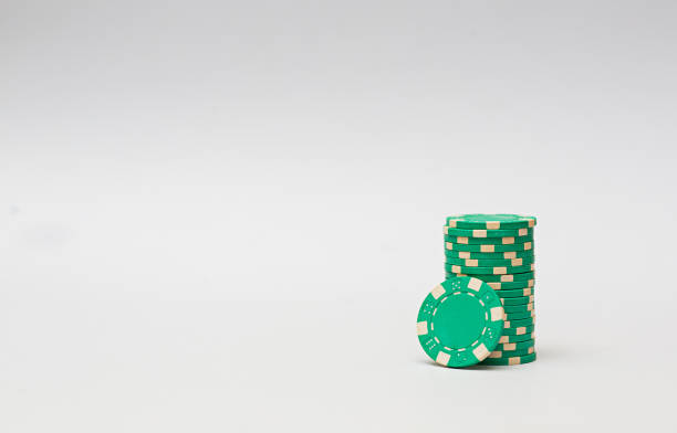 Green casino chips stacked on white background. Poker game.