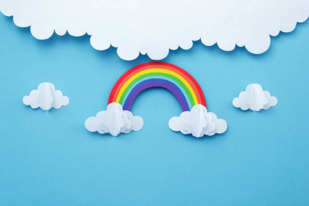 istock Rainbow on blue sky with clouds  made of paper cutout. creative minimal concept. 1544703240