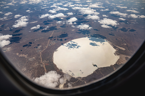 White lake at the steppe landscape, through the airplane window