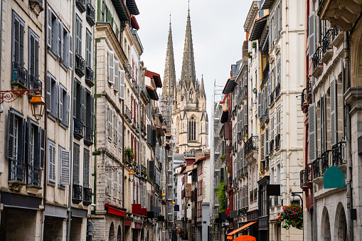 Alley with old buildings and cathedral towers in the background in the city of Bayonne in the south of France