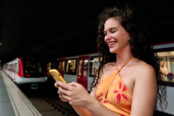 istock beautiful young woman waiting subway and using smartphone 1544713577