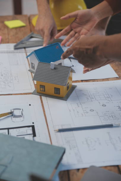 istock Construction and structure concept of engineer working drawing on blueprint meeting for project working with partner on model building and engineering tools in working site, construction concept. 1544802358