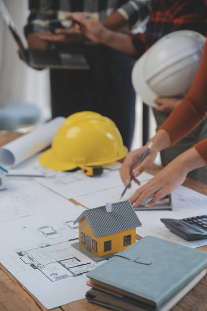 istock Construction and structure concept of engineer working drawing on blueprint meeting for project working with partner on model building and engineering tools in working site, construction concept. 1544802904