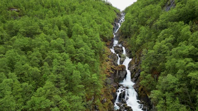 4K drone video of Pyttelva river and waterfall flowing into Bondhusvatnet Lake in Hardanger.