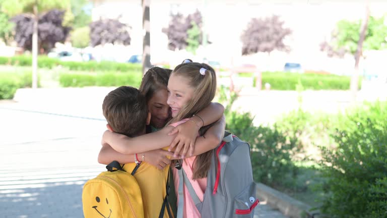 Group Of School Children Embracing Each Other.