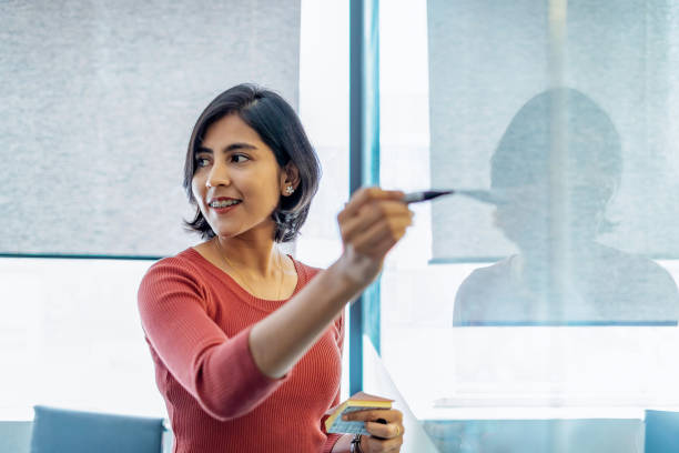 young businesswoman writing on white board in office