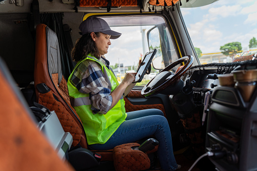 Truck driver setting up navigation GPS equipment to get to destination and deliver goods