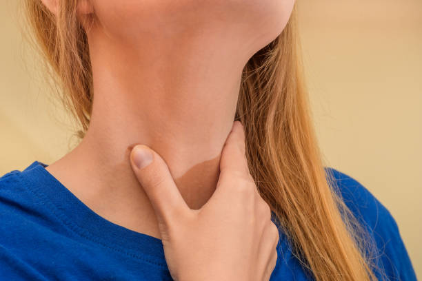 istock Sick thyroid, hypothyroidism, woman holding her neck 1544998560