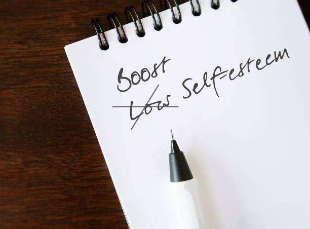 istock Notebook on wood background with handwriting LOW SELF ESTEEM changed to BOOST SELF ESTEEM, to overcome low self worth, feel good and valued own opinion and ideas, which deserve respect from others 1545007117