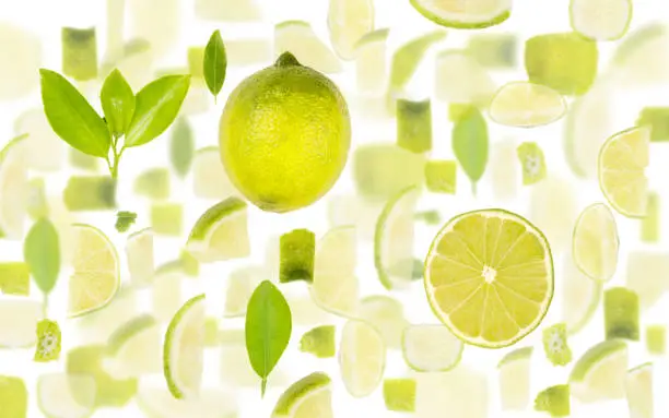 Abstract background made of Lime fruit pieces, slices and leaves isolated on white.