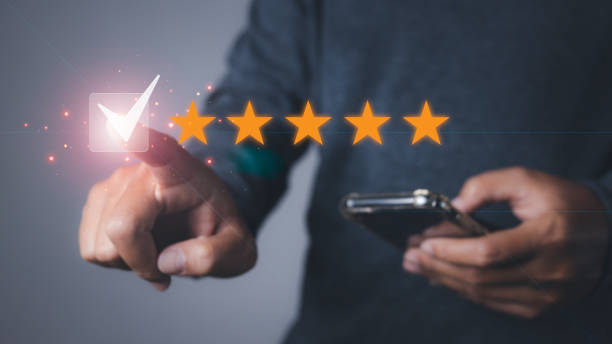 istock Man using phone giving high score with five star icon and excellent satisfaction service. 1545074109