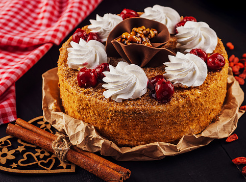 honey cake with cherry and whipped cream