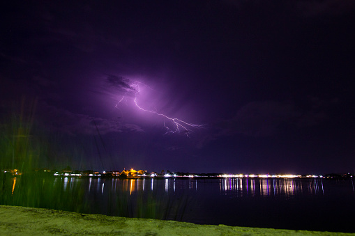 Lightning strikes across a dark cloudy sky during a thunderstorm