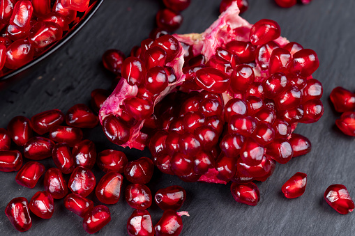Grains of red ripe pomegranate close-up , juicy pomegranate seeds of red color during cooking