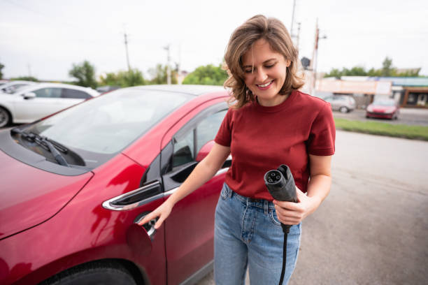 istock Woman  charging red electric car 1545163637