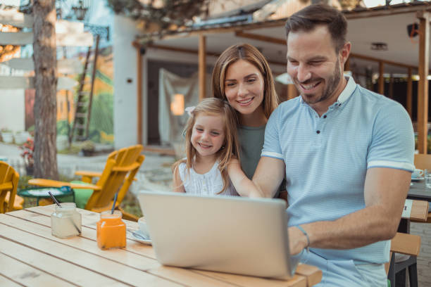 istock Family Using Laptop at Sidewalk Cafe 1545165253