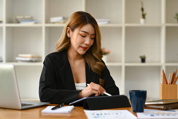 istock Millennial business lady using digital tablet and working on marketing strategy at modern office. 1545203671