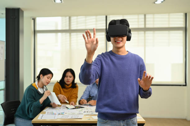 Developers team brainstorming, testing virtual reality simulator glasses at meeting. Innovation, technology and futuristic concept. stock photo