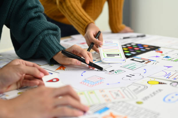 istock Mobile application designers brainstorming and discussing new app features at co working space office. 1545217233