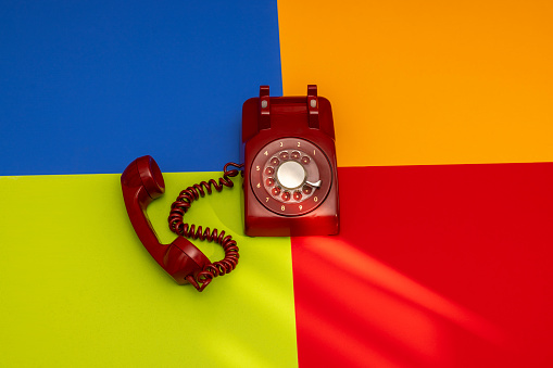 Vintage red landline telephone on color background