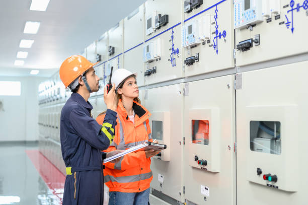 istock Electrical technician worker with personal safety equipment working and checking status from control panel switch board in control room of high voltage electric transformer station. Industrial business occupation worker concept. 1545225744