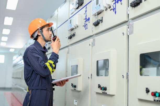 istock Electrical technician worker working and and discussing in control room of high voltage electric switcher transformer station. Industrial business occupation worker concept. 1545226267
