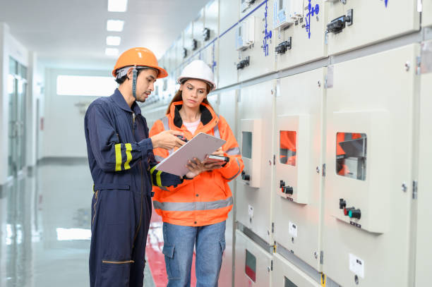 istock Electrical technician worker working and and discussing in control room of high voltage electric transformer station. Industrial business occupation worker concept. 1545226802