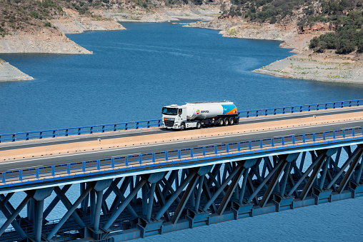 Tanker truck of the Repsol energy company circulating through a viaduct.