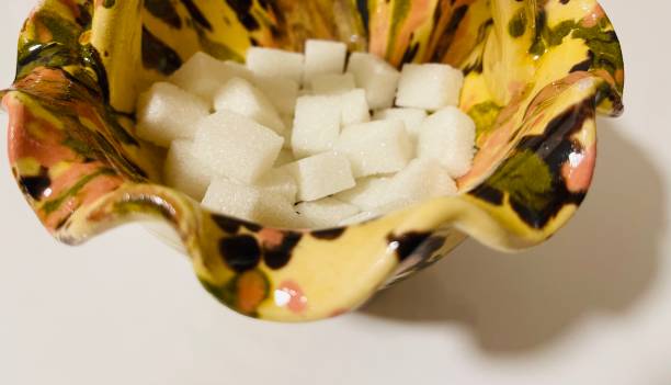 istock Porcelain sugar bowl and many sugar cubes on white background 1545304735